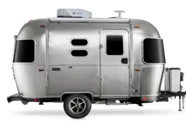 Seitenansicht eines silbernen Airstream Caravel 16RB 2026 Reiseanhängers mit charakteristisch abgerundeter Aluminiumkarosserie und moderner Ausstattung.