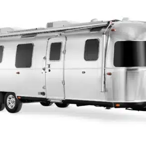 Seitenansicht eines silbernen Airstream Classic 2026 als luxuriöser Doppelachser-Reisewohnwagen.