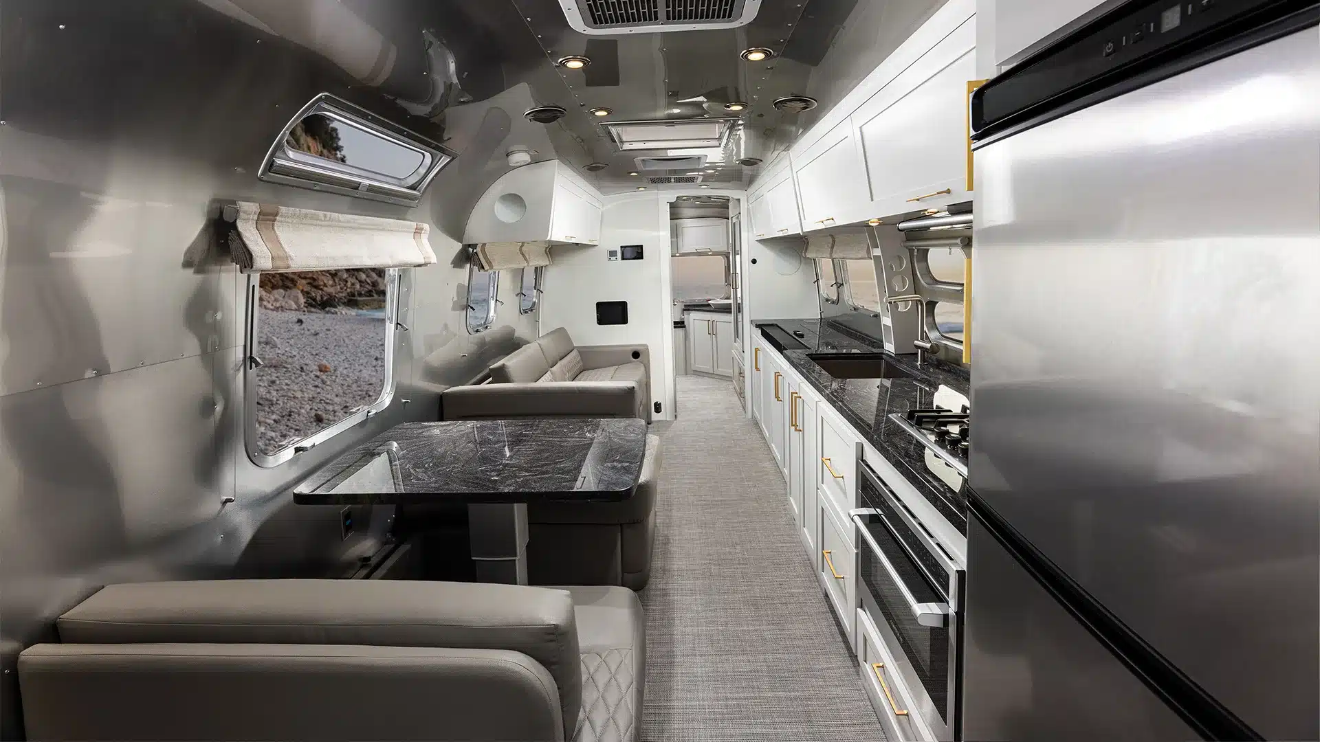 Innenansicht eines hochwertig ausgestatteten Airstream Classic 2026 Wohnwagens mit Küche, Sitzbereich und modernen Oberflächen