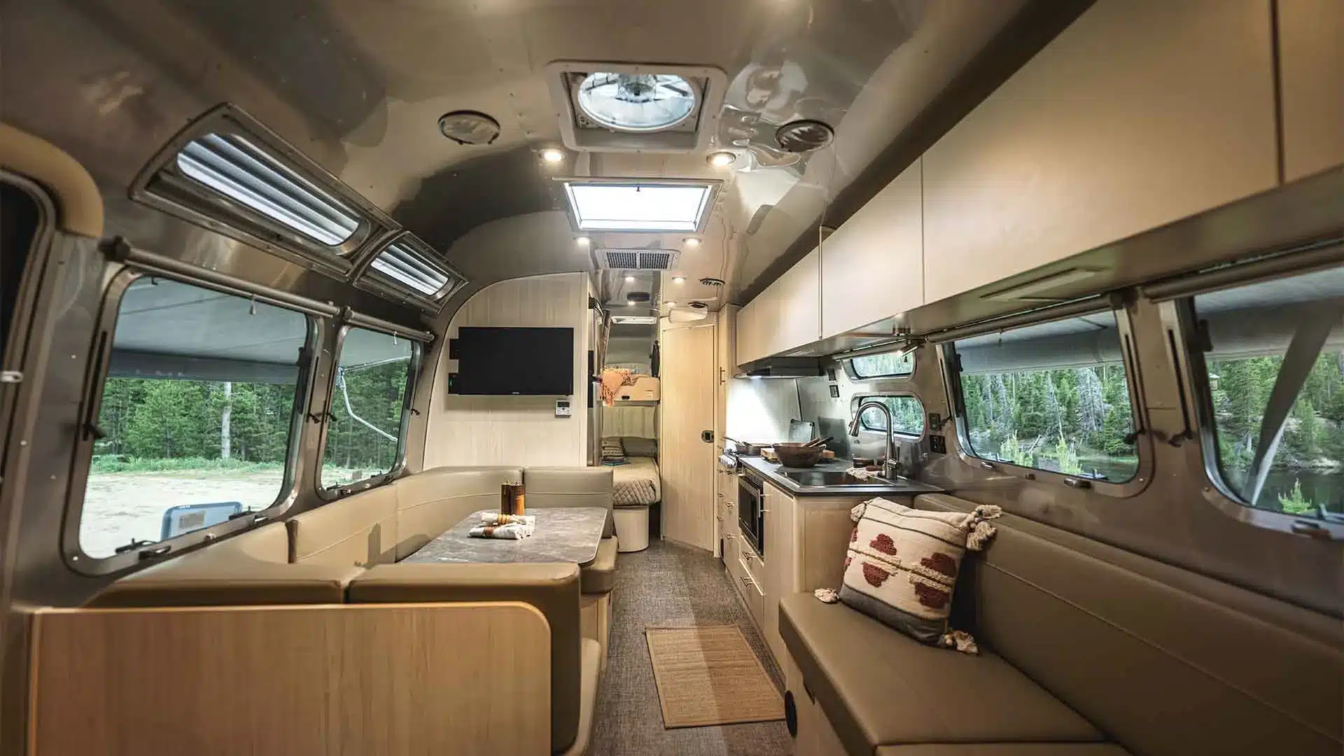 Moderner Innenraum eines Airstream Flying Cloud 30FB Bunk mit großzügigem Wohnbereich, Dinette, Sofa und Küche