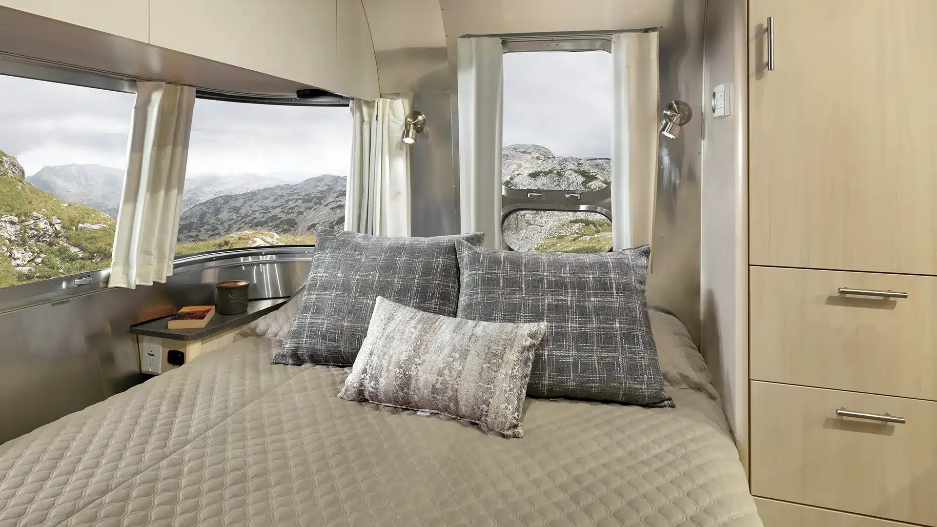 Innenansicht des Schlafbereichs mit Queen-Size-Bett und großen Fenstern im Airstream Flying Cloud 30FB Bunk
