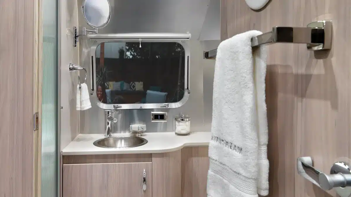 Badezimmer mit Waschbecken, Spiegel und Handtuch im Airstream Globetrotter Wohnanhänger.
