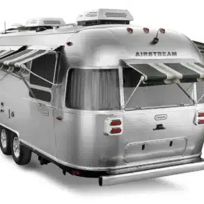 Airstream Globetrotter Wohnanhänger mit aufgeklappter Markise, sieht man von hinten seitlich.