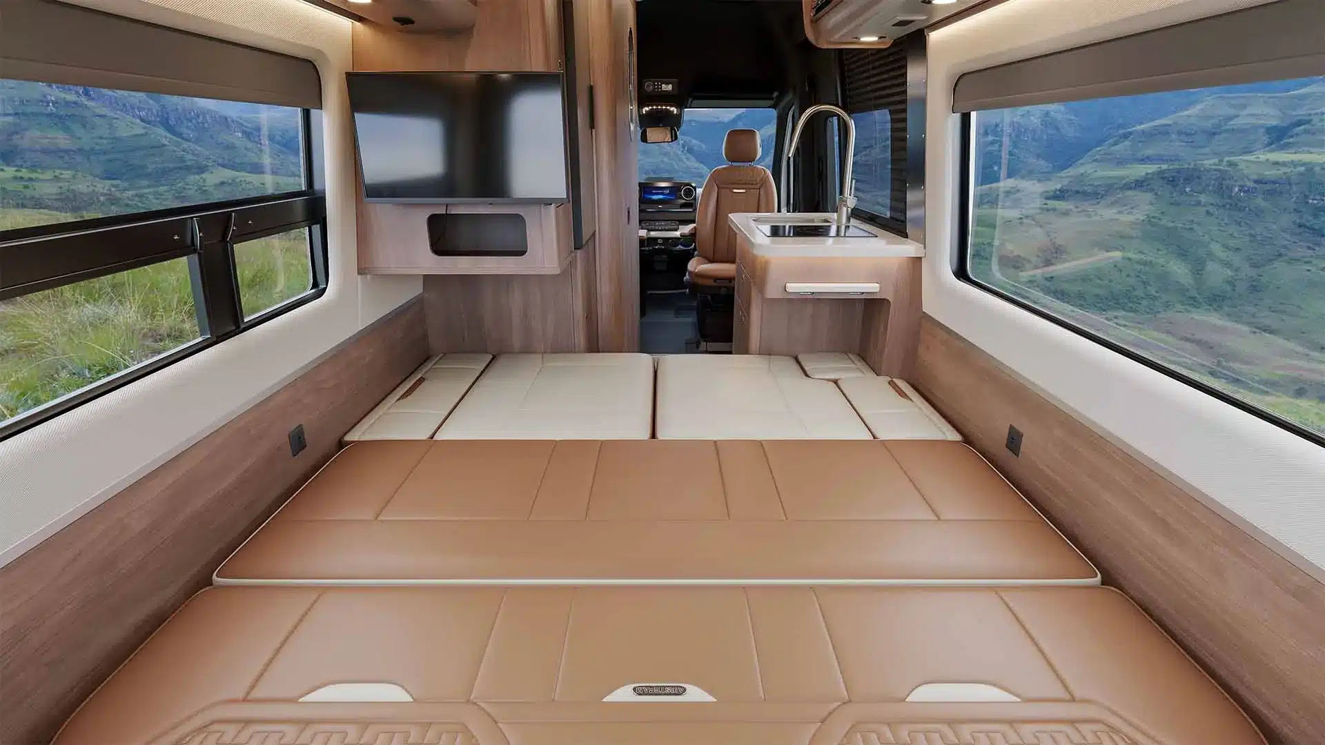 Schlaf- und Wohnbereich im Airstream Interstate 19GTX mit breiter Liegefläche, Küche und moderner Einrichtung