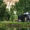 Airstream Rangeline 2026 Camper-Van mit Markise und geöffnetem Aufstelldach an einem Seeufer