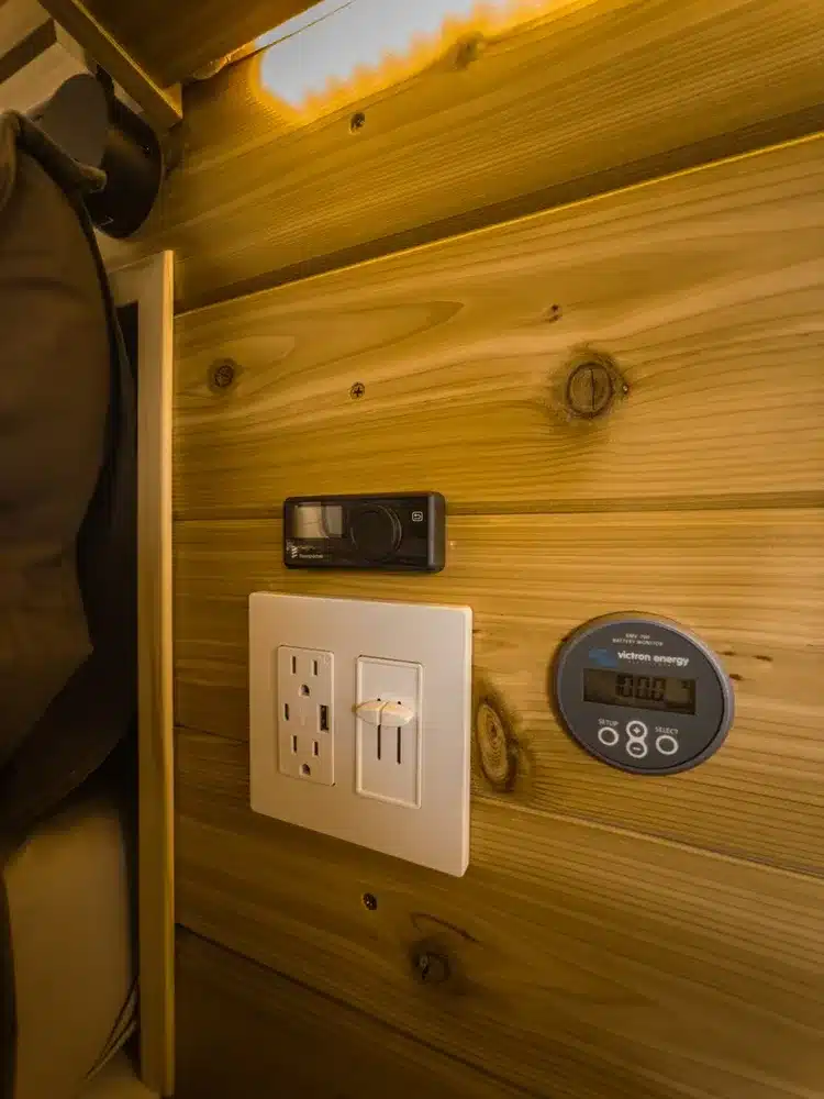 Bedienpanel, Steckdosen und Victron Energy Display im Holzausbau des Campervans Boho Jean