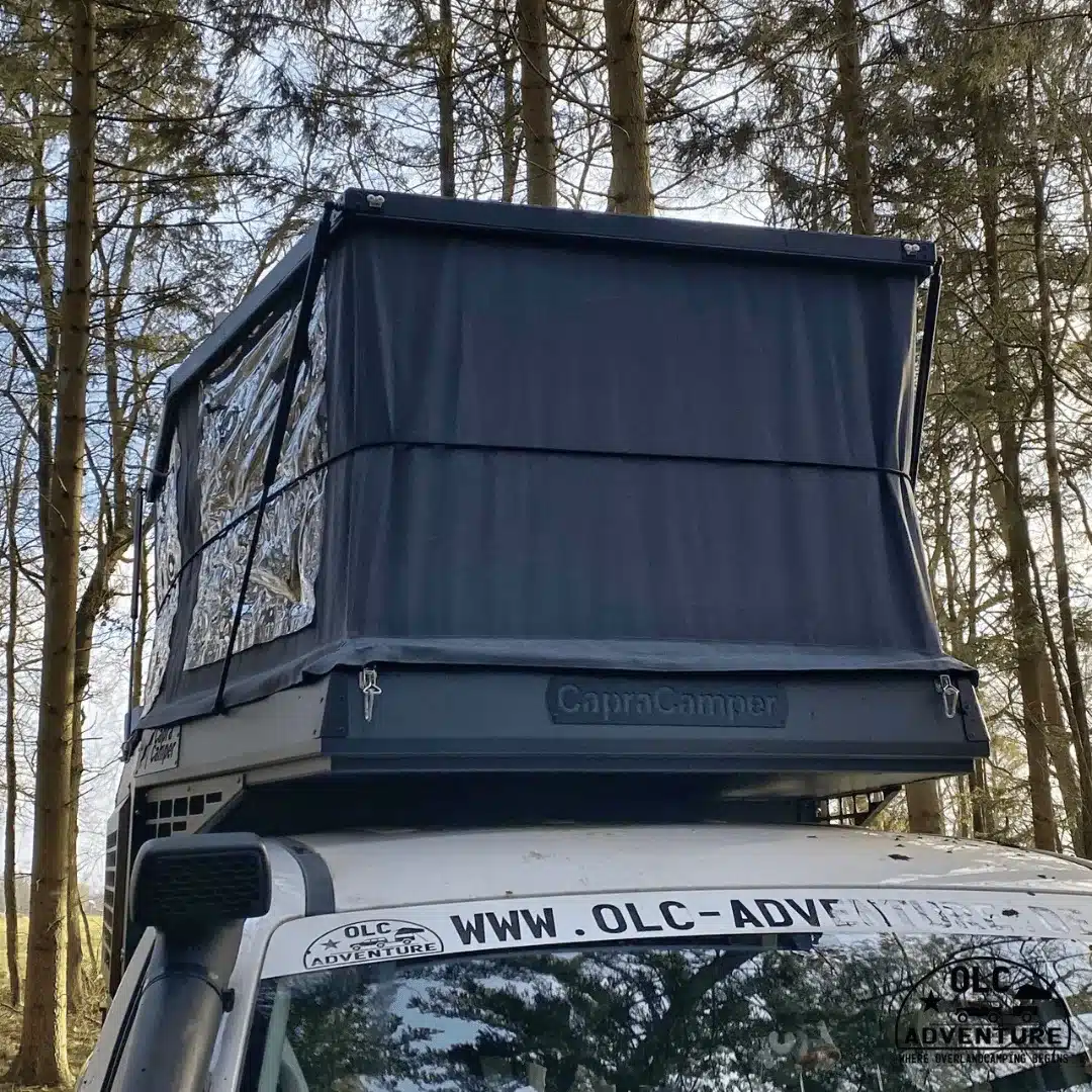 Pop-up-Wohnkabine Capra Camper 3.0 auf Pick-up mit Doppelkabine, aufgebaut im Wald.