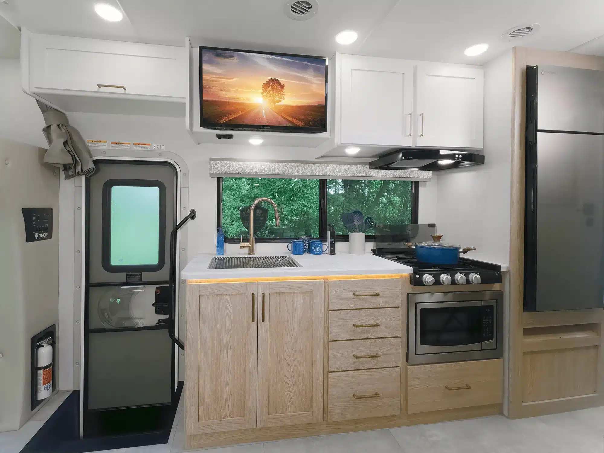 Innenraum des Chateau Sprinter 24LT mit Küchenzeile, Herd, Spüle, Kühlschrank und Fernseher.