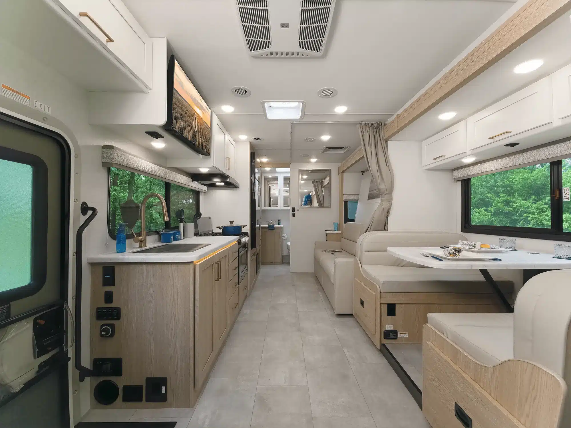 Innenraum eines Chateau Sprinter 24LT Wohnmobils mit Küche, Sitzgruppe und hellen Holzmöbeln.