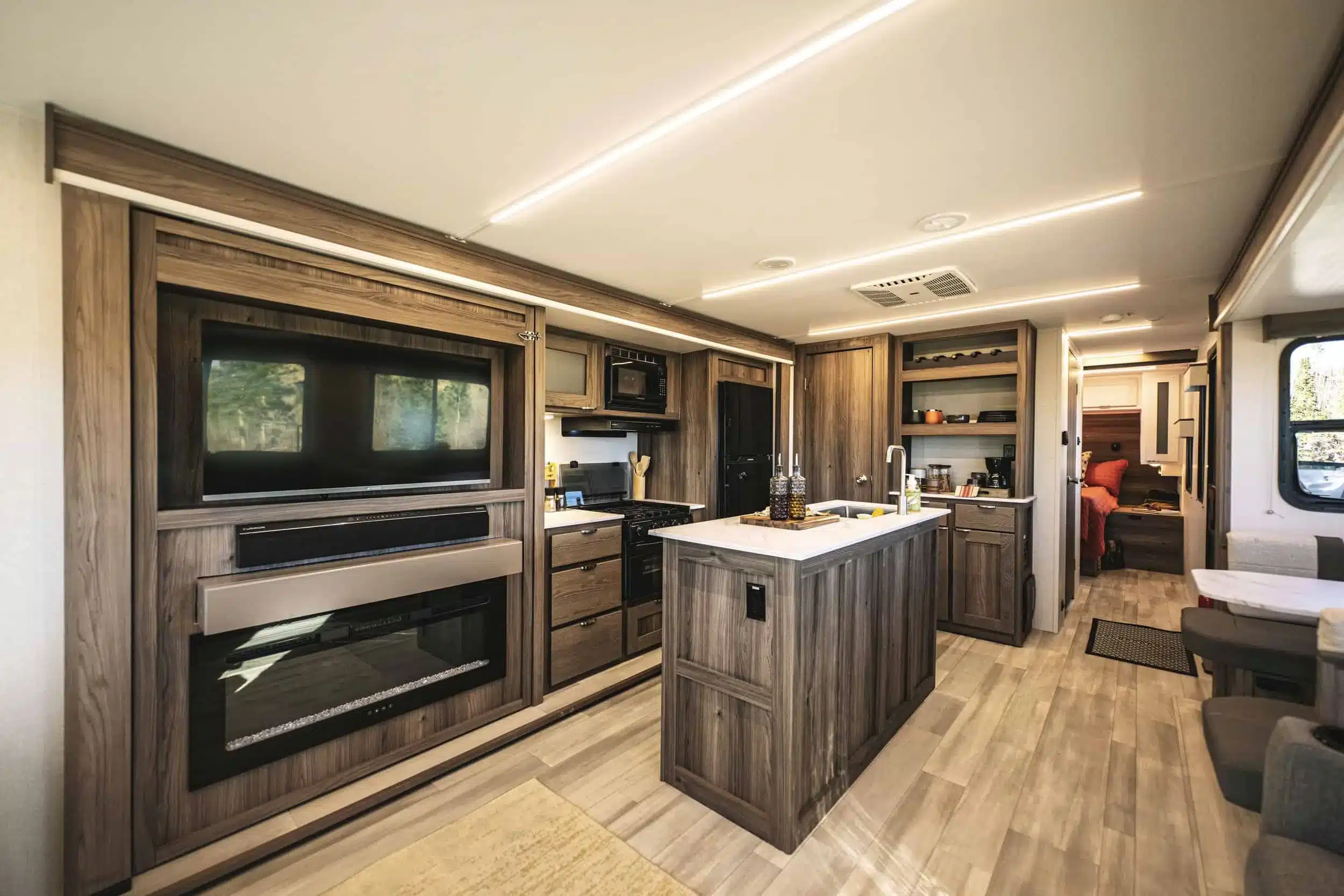 Moderner, geräumiger Innenraum eines Cruiser MPG 3010RL Wohnanhängers mit Küche, Wohnbereich und Blick ins Schlafzimmer