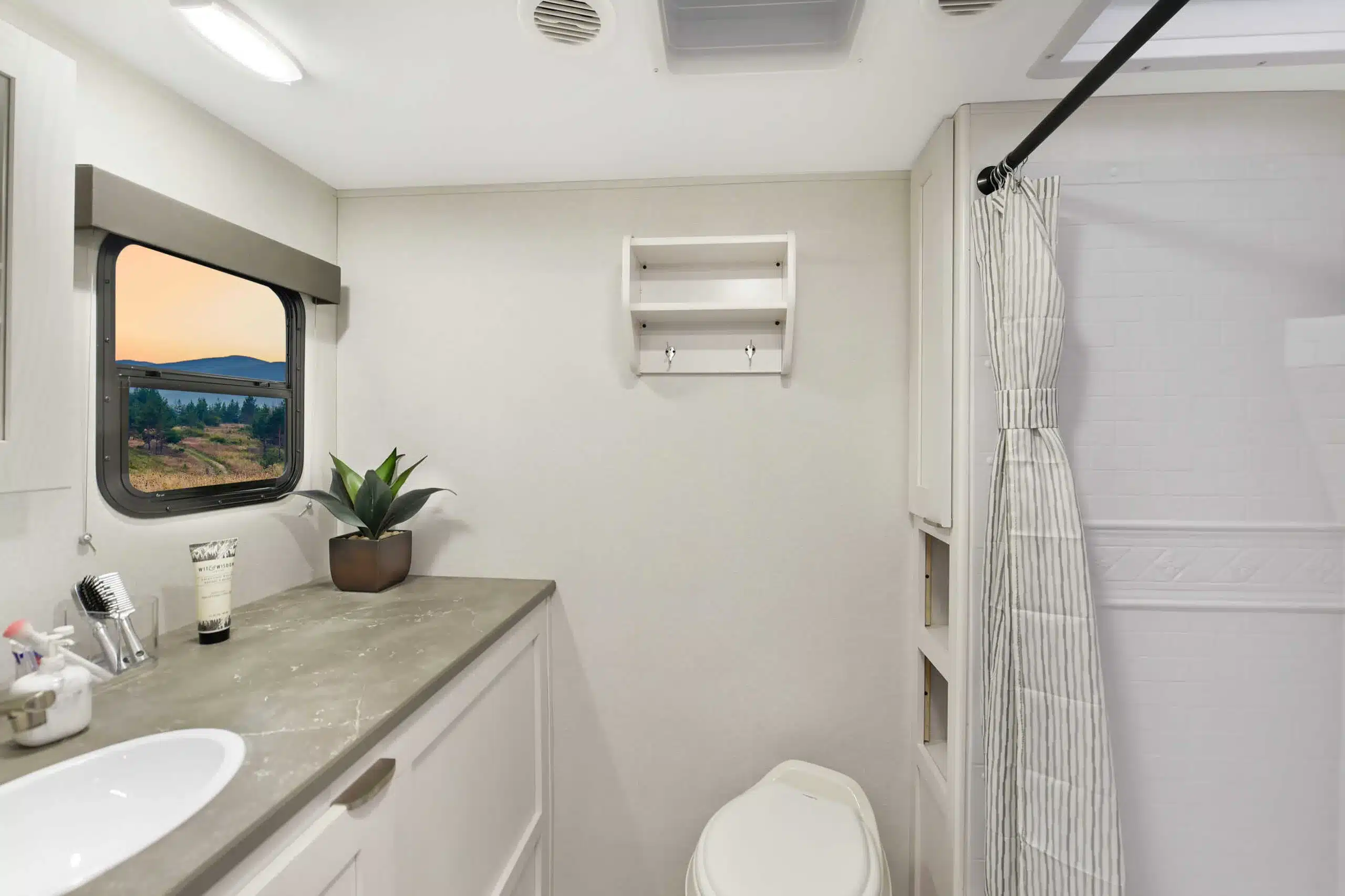 Bad mit Fenster, Waschbecken, WC und Duschbereich im Cruiser RV MPG 2650RB Wohnwagen.