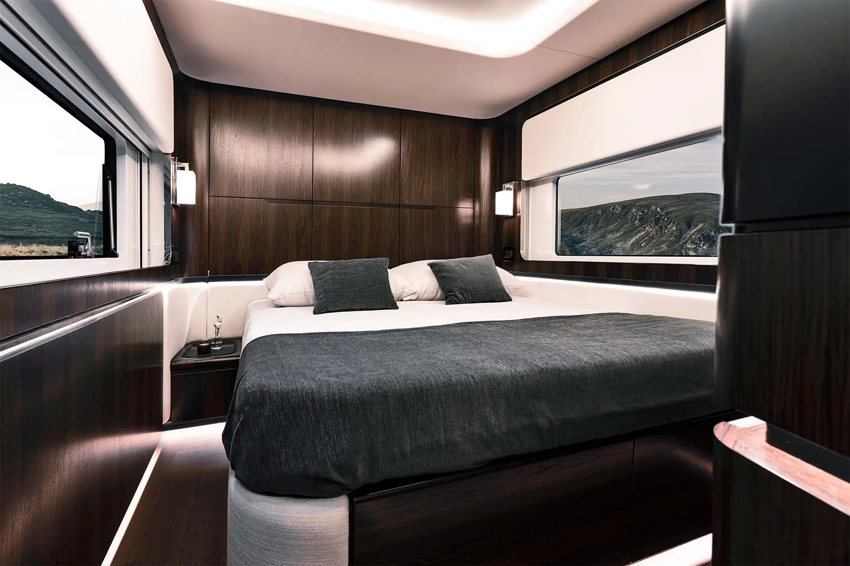 Luxuriöses Schlafzimmer mit Doppelbett und Holzverkleidung im Dembell Smart-Garage Reisemobil