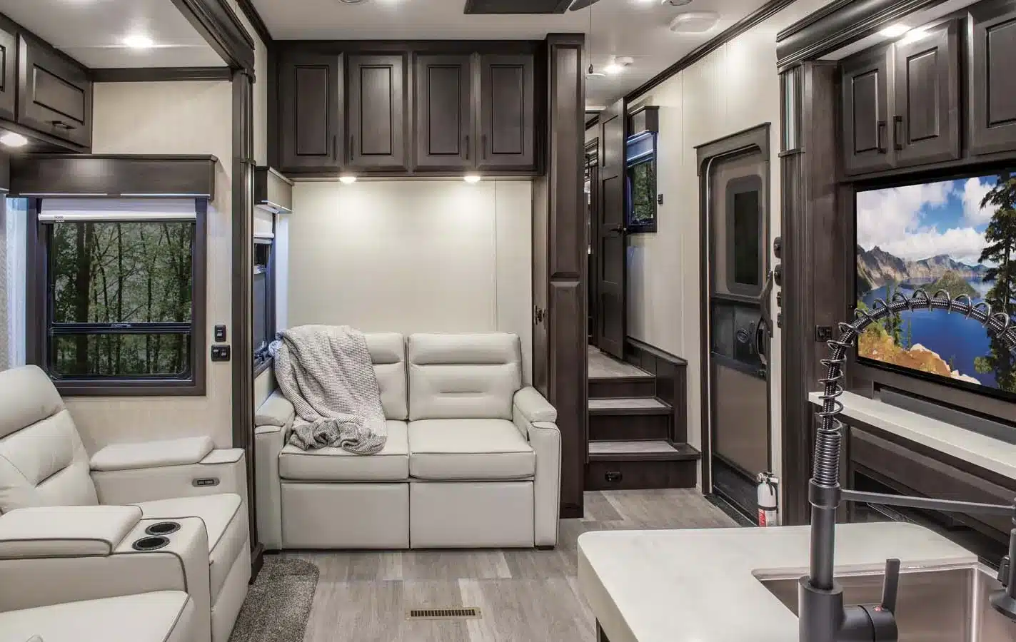 Wohnbereich und Küche des DRV Suites MX450 Toyhauler mit Sofa und großem Fernseher