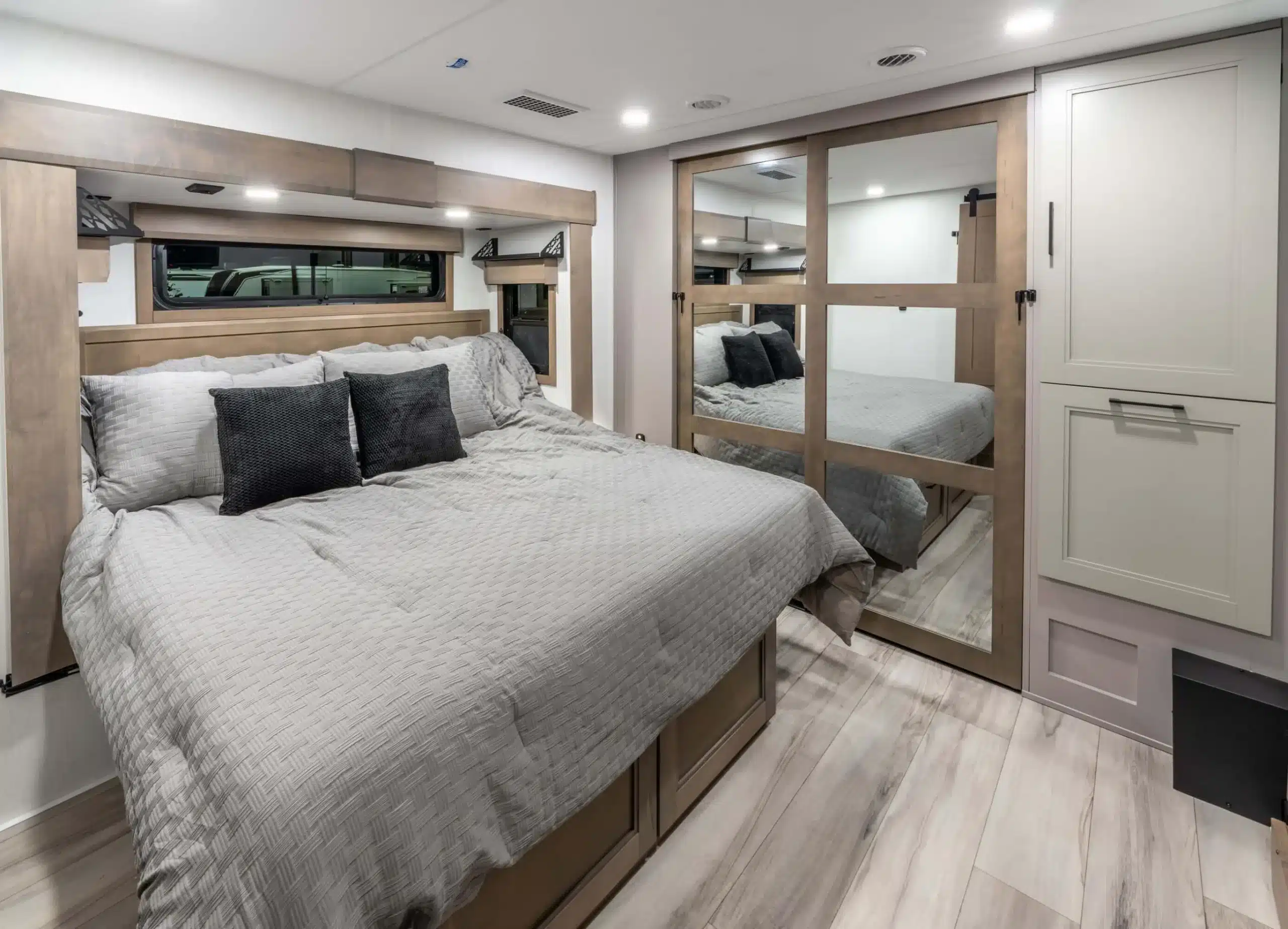 Schlafzimmer mit King-Size-Bett und Spiegelschrank in einem Luxus-Wohnauflieger Durango Gold