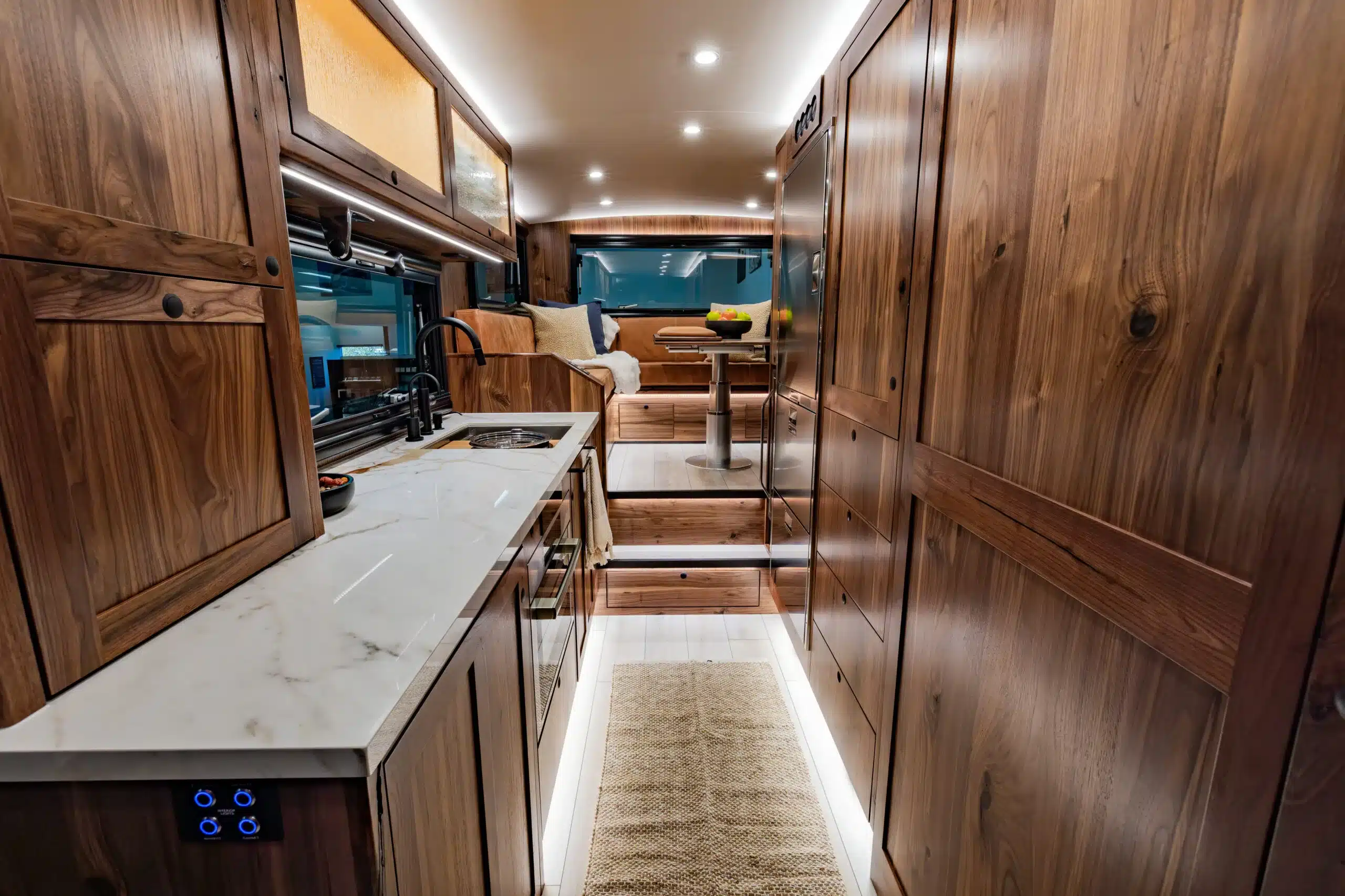 Blick in den stilvollen Innenraum des EarthRoamer SX Explore Expeditionsmobils mit edler Holzausstattung, Küche und Sitzecke.