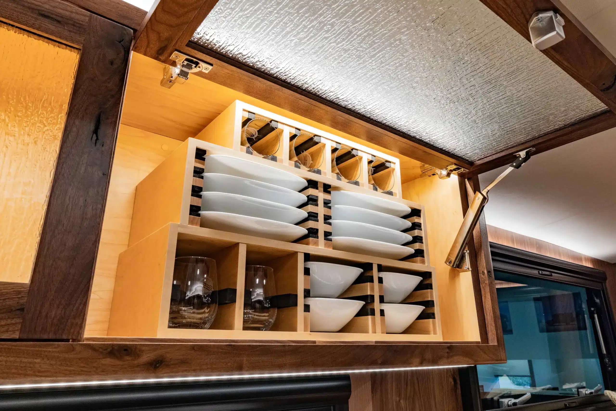 Hängeschrank mit sicher verstautem Geschirr und Gläsern im EarthRoamer SX Explore.