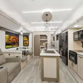 Innenraum des Essence E-28RL Fifth-Wheel mit moderner Küche, Sitzbereich und großen Fenstern