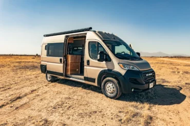 Faith RAM Promaster Camper Van mit geöffneter Schiebetür im Wüstengebiet