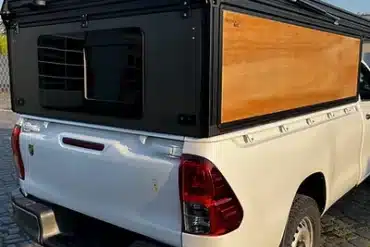 Ein Pick-up mit FLEXS Ladeflächen-System und Canopy-Aufbau in Straßenansicht.
