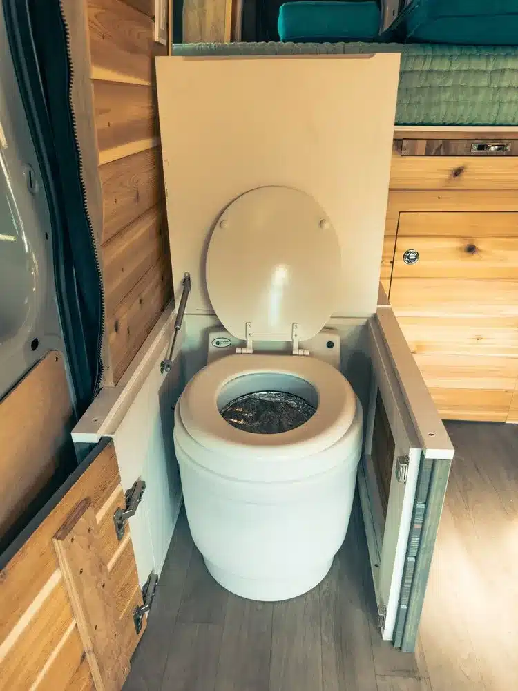 Laveo Dryflush Toilette eingebaut im MJÖLNIR-Campervan auf Basis Ford Transit Trail, umgeben von Holzverkleidung
