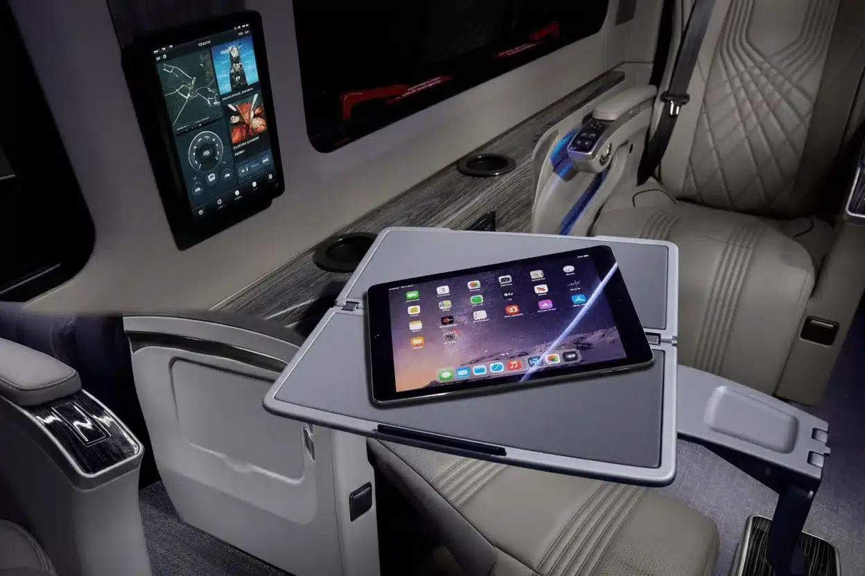 Luxuriöser Innenraum eines Grech LUSSO Lounge Vans mit Tablet auf dem Klapptisch und Bedien-Display an der Wand.