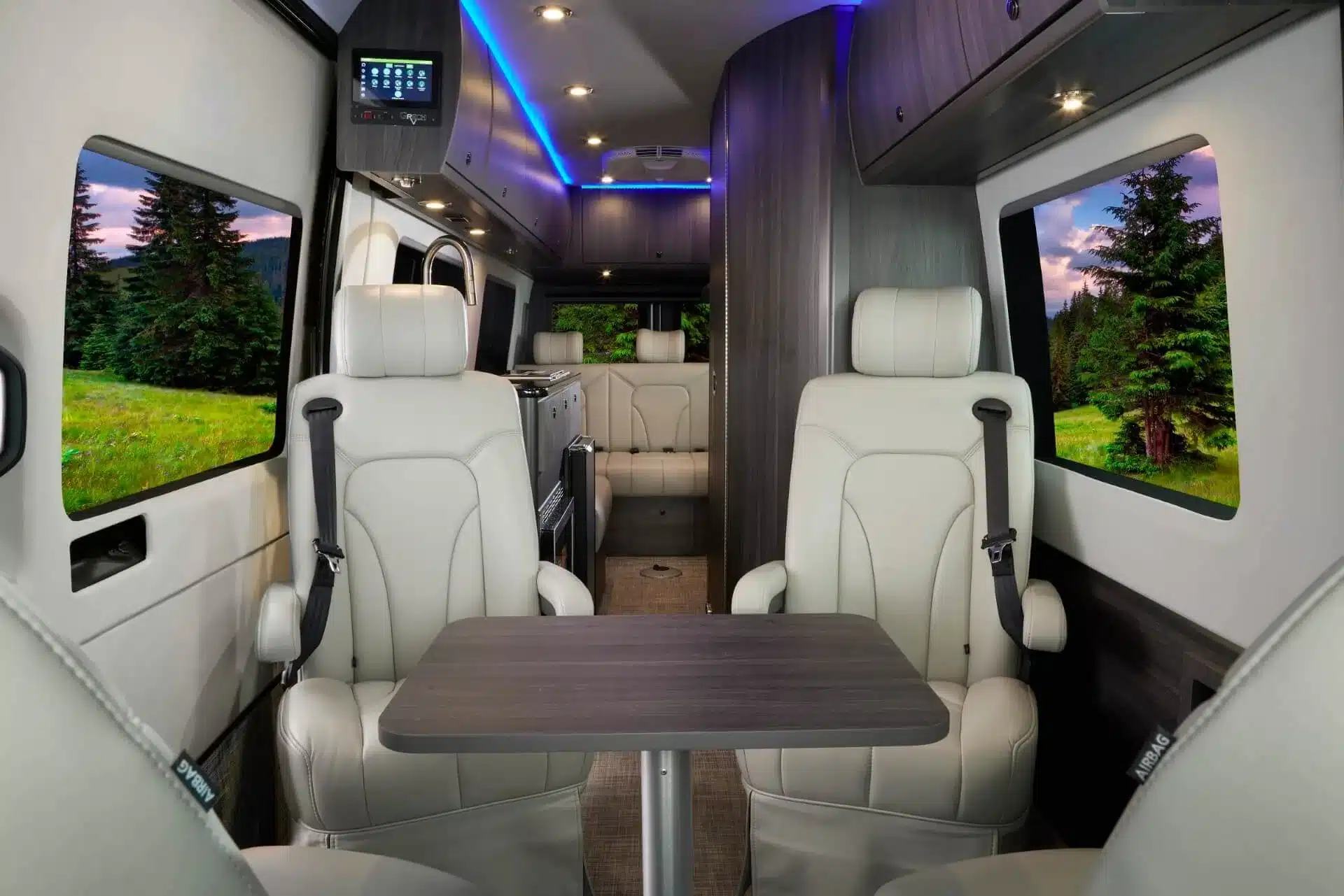 Innenraum des Grech RV STRADA-ion AWD mit luxuriöser Lounge-Bestuhlung und Tisch, moderne LED-Beleuchtung und hochwertige Materialien.