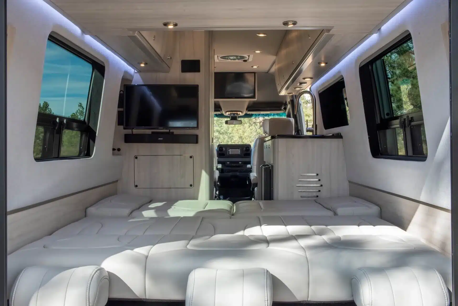 Innenraum des Grech Strada-ion Campervans mit Memory-Foam-Bett, LED-Beleuchtung und TV auf Mercedes Sprinter Basis.