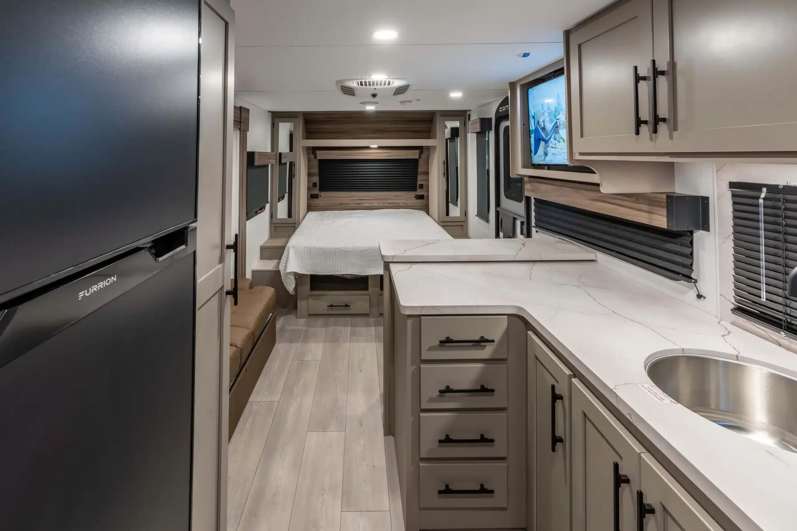 Innenansicht eines KZ Connect Mini Wohnwagens mit Küche, Bett und modernen Einbaumöbeln