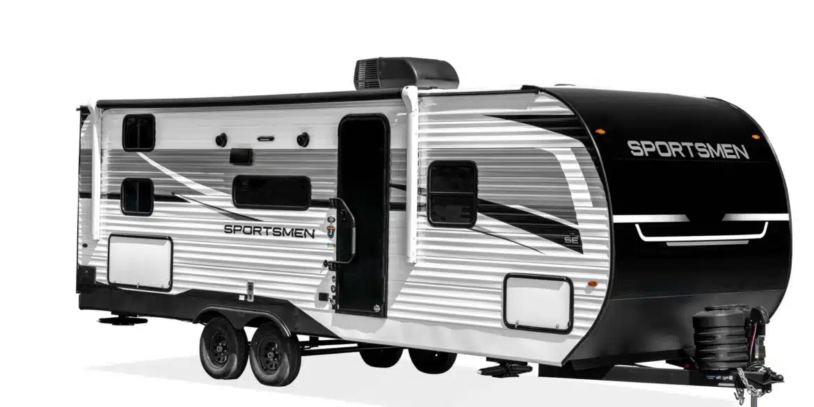 Seitenansicht des KZ Sportsmen SE Travel Trailers mit markanter Grafik und Glastür.