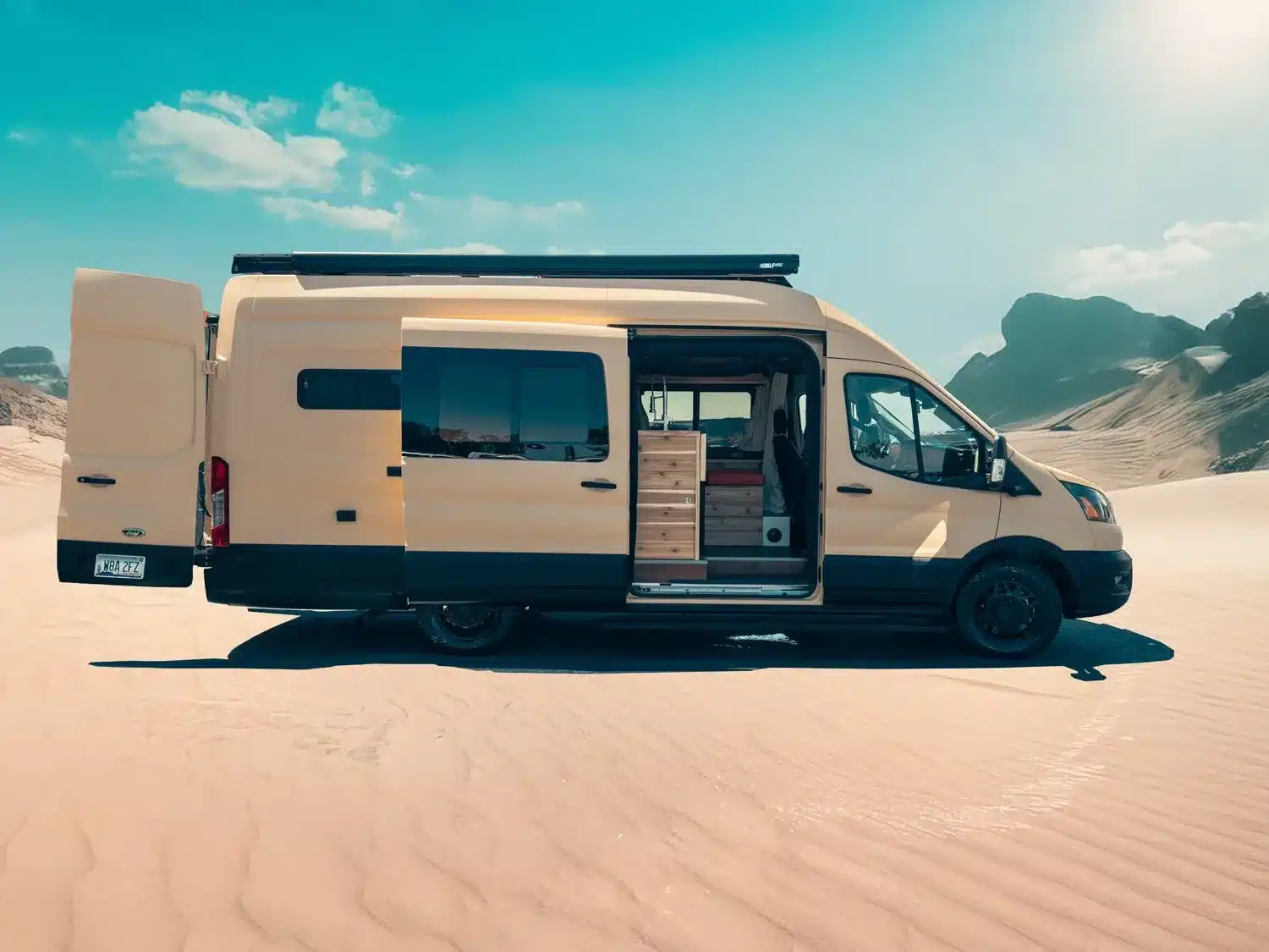Ford Transit Lonely Cactus 2 Campervan mit ausgebautem Innenraum und geöffneter Seitentür in einer Wüste.