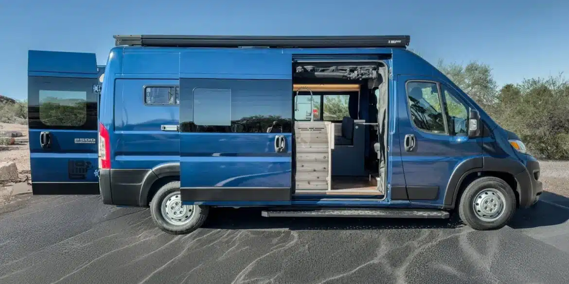 Seitenansicht eines blauen Matt Foley II Campervans mit geöffneten Türen und sichtbarem Innenausbau.