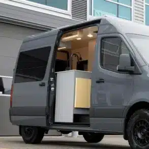 Der Mercedes Sprinter The Pinery Campervan mit geöffneter Schiebetür und sichtbarer Innenküche
