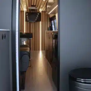 Blick in den Innenraum eines Mobile Clinic Vans mit Untersuchungsliege, Schränken und Beleuchtung.