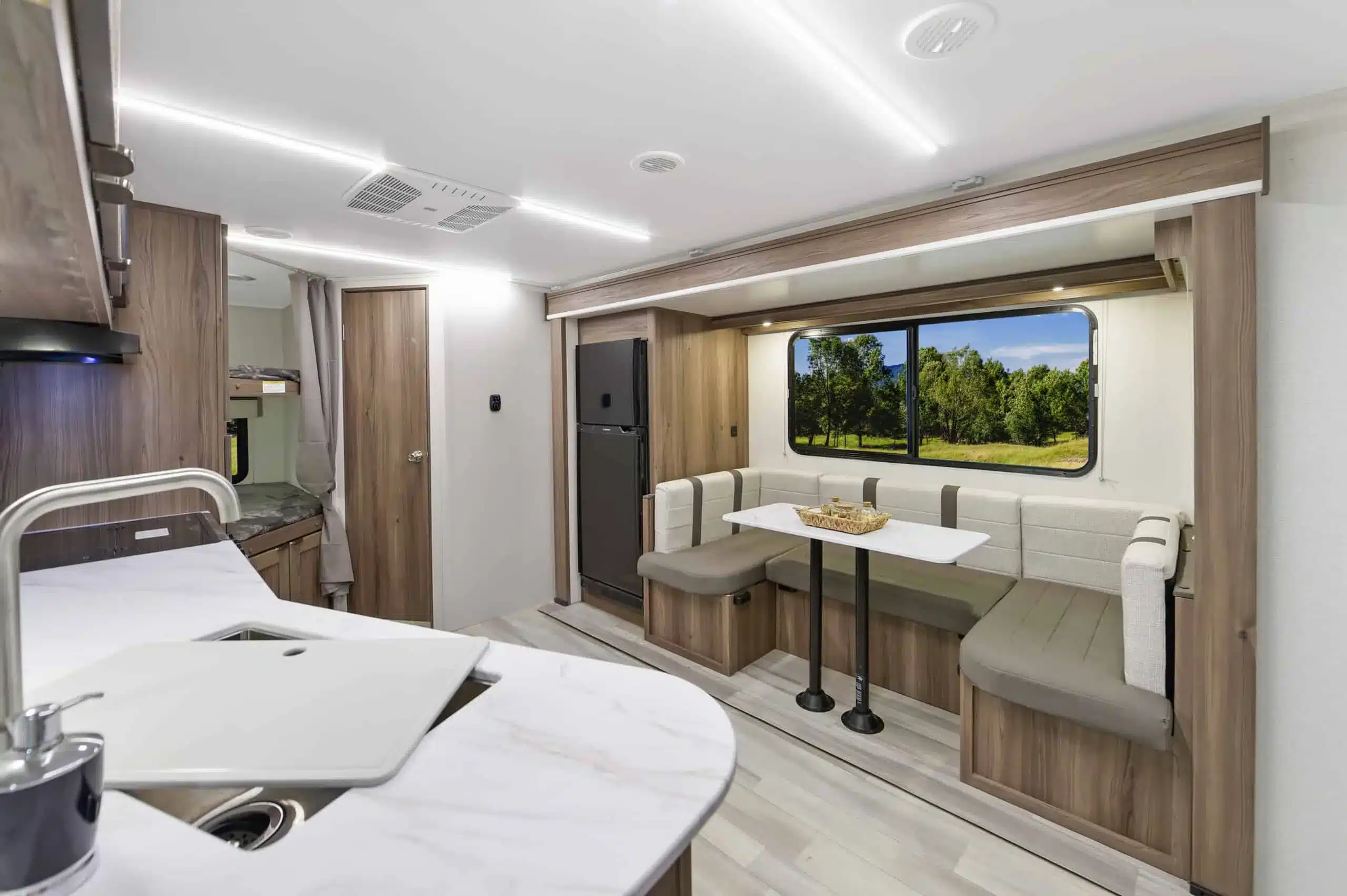 Innenansicht des MPG 2520BH Travel Trailers mit Küche, Sitzgruppe und Etagenbetten.
