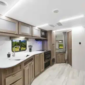 Innenansicht des MPG 2520BH Travel Trailers mit Küche, Stauraum und Etagenbetten.