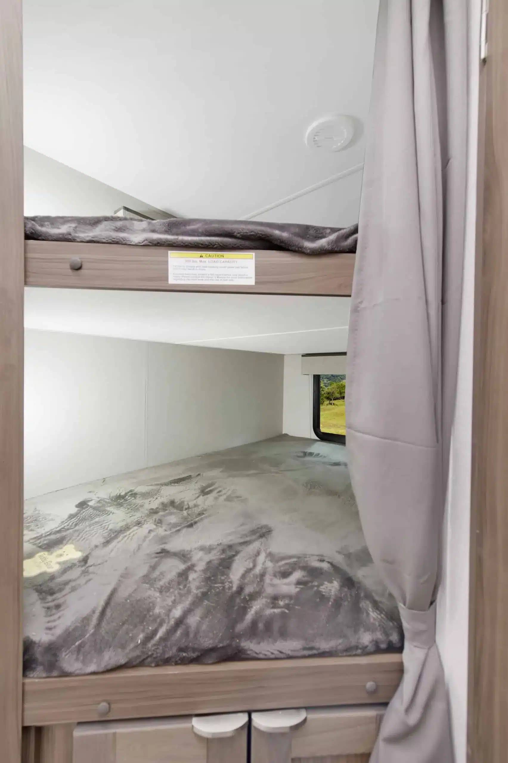 Stockbetten mit Vorhang im Innenraum des MPG 2520BH Wohnwagens