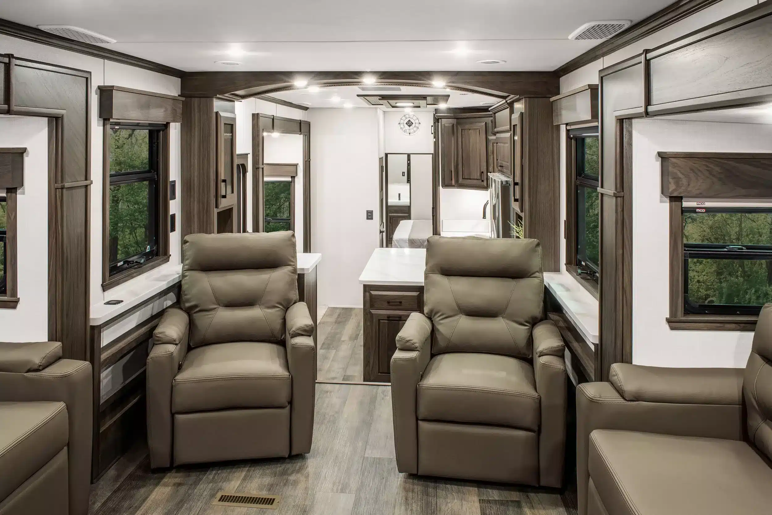 Wohnbereich der MS Nashville mit hochwertigen Ledersesseln, Massivholzelementen und Blick in die Küche