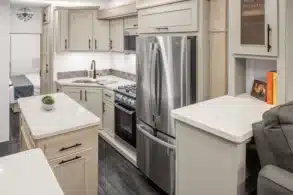 Moderne Küche mit Edelstahl-Kühlschrank und Gasherd im Innenraum des Wohnaufliegers MS Nashville von DRV Suites.