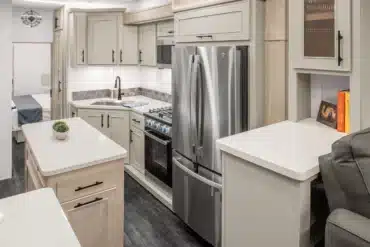 Moderne Küche mit Edelstahl-Kühlschrank und Gasherd im Innenraum des Wohnaufliegers MS Nashville von DRV Suites.