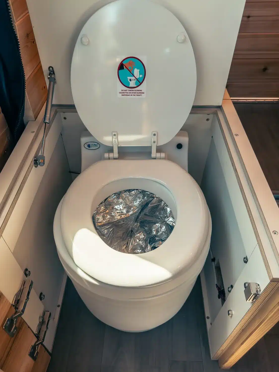 Laveo Dry Flush Trockentoilette im Innenraum eines ausgebauten Campervans, eingebaut in einen Holzschrank