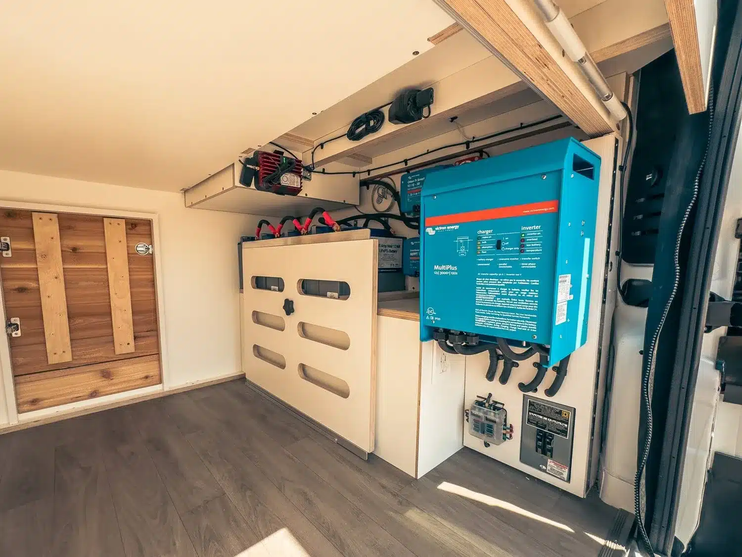 Elektrikbereich im Heck eines Sage Campervans mit blauer Victron-Multiplus-Anlage und Lithiumbatterien.