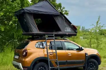 OLC140ALU 2.0 Dachzelt in aufgeklapptem Zustand auf einem orangefarbenen SUV mit Leiter im Freien