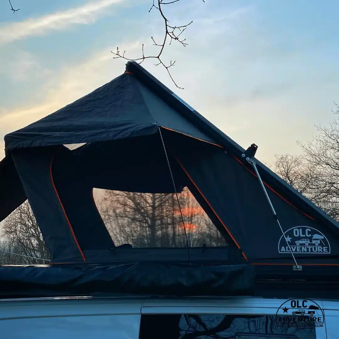 OLC140ALU 2.0 Dachzelt mit ausklappbarem Erker auf einem Fahrzeugdach, geöffnet bei Sonnenuntergang