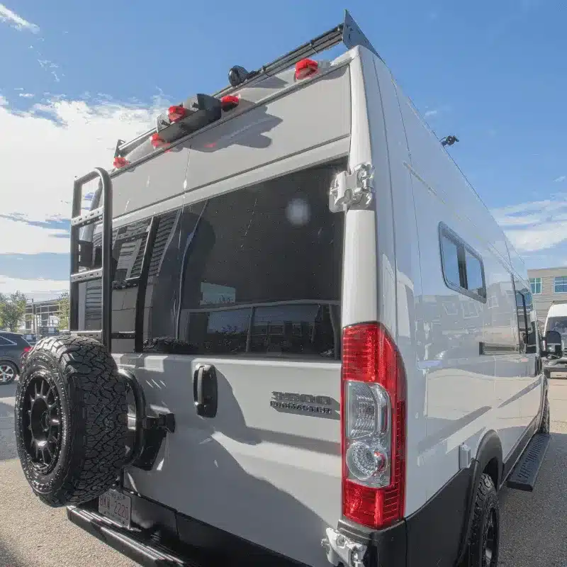 Der Ram Falls Campervan von hinten mit montiertem Ersatzrad, Leiter und Dachträger