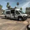 Ram Promaster Campervan mit geöffneter Seitentür unter Palmen in San Diego, Kalifornien