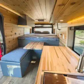 Holzausbau und Innenraum des Red Rover Vans mit festem Bett und Arbeitsfläche