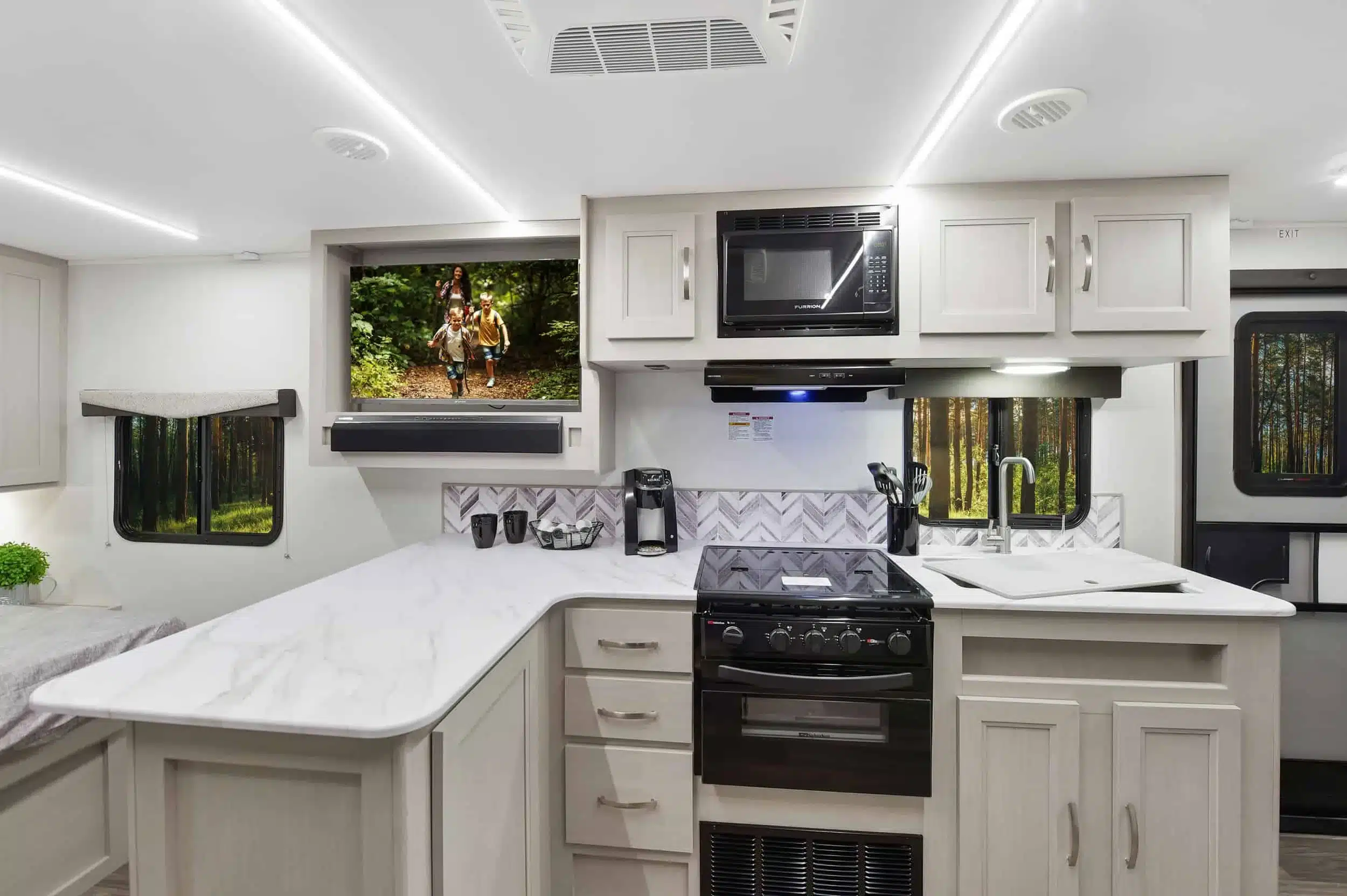 Innenansicht des Shadow Cruiser 235RBS mit Küche, Backofen, Mikrowelle, Spüle und Wohnbereich.
