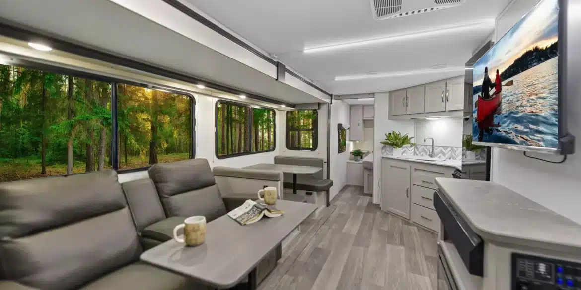 Innenansicht des Shadow Cruiser 261RB Wohnanhängers mit gemütlicher Sitzgruppe, Küche und Fernseher.