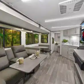 Innenansicht des Shadow Cruiser 261RB Wohnanhängers mit gemütlicher Sitzgruppe, Küche und Fernseher.