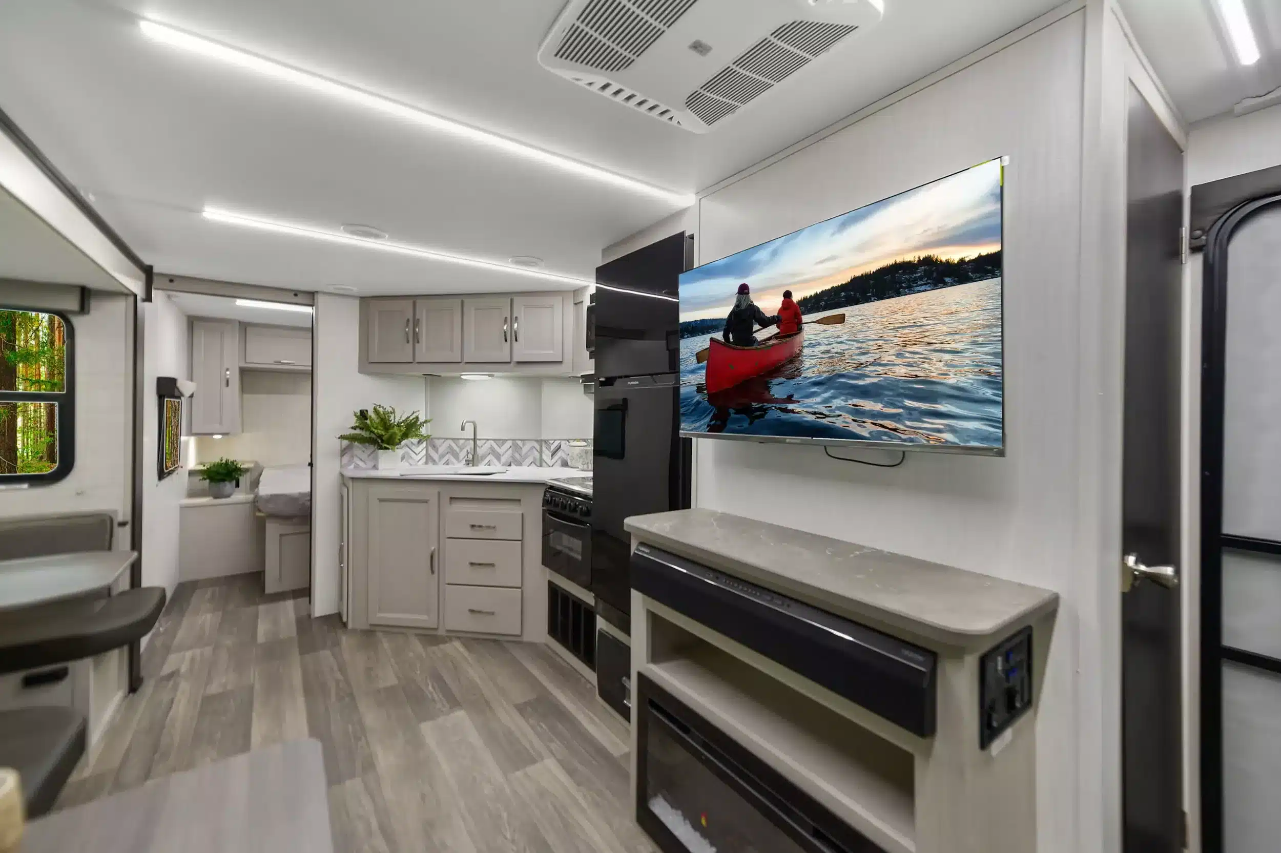 Wohnbereich und Küche des Shadow Cruiser 261RB Travel Trailer mit Fernseher, Einbauküche und Elektro-Kamin